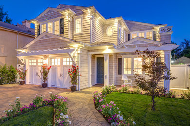 Example of a mid-sized classic beige two-story wood exterior home design in Los Angeles with a shingle roof