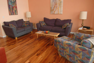 This is an example of a mid-sized traditional formal living room in Seattle with orange walls and light hardwood floors.