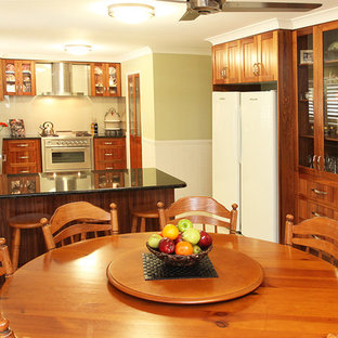 Mid-sized traditional kitchen pantry pictures - Inspiration for a mid-sized timeless u-shaped ceramic floor and beige floor kitchen pantry remodel in Brisbane with medium tone wood cabinets, stainless steel appliances, an undermount sink, recessed-panel cabinets, granite countertops, beige backsplash, glass sheet backsplash and a peninsula