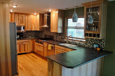 Example of a mid-sized mountain style u-shaped light wood floor eat-in kitchen design in Other with an undermount sink, flat-panel cabinets, light wood cabinets, solid surface countertops, stainless steel appliances, a peninsula and brown countertops