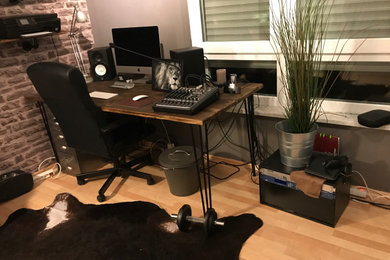 Kleines Industrial Arbeitszimmer mit Studio, brauner Wandfarbe, Laminat, freistehendem Schreibtisch, braunem Boden und Tapetenwänden in München