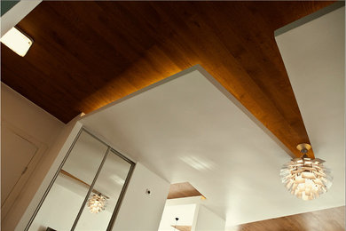 Diseño de salón tipo loft contemporáneo con paredes blancas, suelo de madera en tonos medios y suelo marrón
