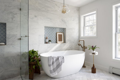 Example of a large master marble tile marble floor, white floor and double-sink bathroom design in Boston with blue cabinets, a bidet, gray walls, an undermount sink, quartz countertops, a hinged shower door, white countertops and a niche