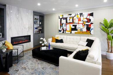 Large eclectic open concept medium tone wood floor, brown floor and wall paneling living room photo in Toronto with beige walls, a ribbon fireplace, a stone fireplace and a wall-mounted tv