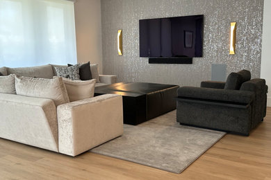 Inspiration for a mid-sized modern formal and open concept laminate floor, brown floor, tray ceiling and wallpaper living room remodel in Las Vegas with gray walls and a wall-mounted tv