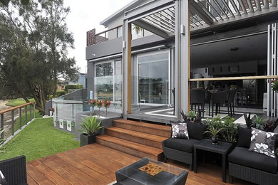Design ideas for a small contemporary backyard deck in Central Coast with a pergola.