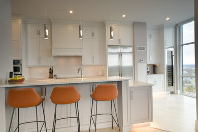 Mid-sized transitional open concept kitchen photo in Toronto with shaker cabinets, white cabinets, quartz countertops, stainless steel appliances, a peninsula and white countertops