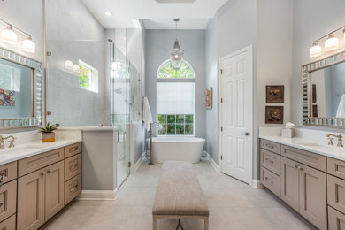 Bathroom - large transitional master gray tile porcelain tile, beige floor and single-sink bathroom idea in Jacksonville with recessed-panel cabinets, a two-piece toilet, gray walls, an undermount sink, quartz countertops, a hinged shower door, white countertops and a built-in vanity