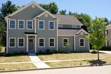 Example of a large classic gray two-story vinyl house exterior design in Cleveland with a hip roof and a shingle roof