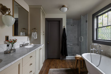 Eclectic master gray tile dark wood floor, brown floor and double-sink bathroom photo in Denver with recessed-panel cabinets, beige cabinets, beige walls, an undermount sink, gray countertops and a built-in vanity