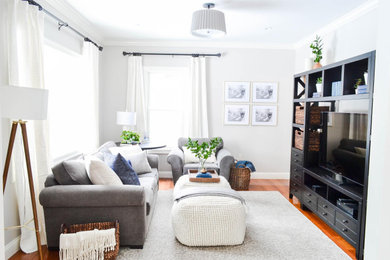 Inspiration for a transitional medium tone wood floor family room remodel in Boston with gray walls and a tv stand
