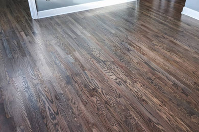 Mid-sized minimalist open concept medium tone wood floor and gray floor family room photo in New York with gray walls and no fireplace