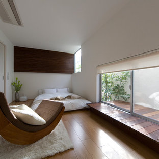 Ispirazione per una camera da letto etnica con pareti bianche, pavimento in legno massello medio e nessun camino