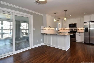 Large transitional u-shaped open concept kitchen photo in Bridgeport with an undermount sink, shaker cabinets, white cabinets, granite countertops, white backsplash, subway tile backsplash, stainless steel appliances and no island