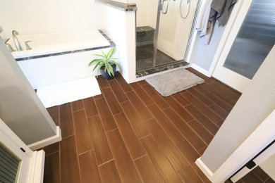 Inspiration for a mid-sized modern master white tile and porcelain tile porcelain tile and brown floor bathroom remodel in Denver with glass-front cabinets, white cabinets, a bidet, gray walls, an undermount sink, soapstone countertops, a hinged shower door and black countertops