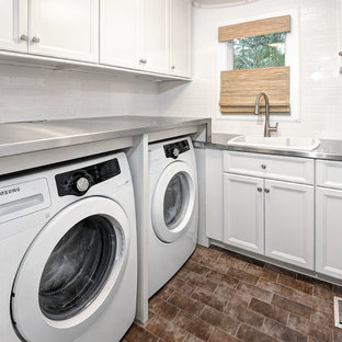 This is an example of a small traditional l-shaped separated utility room in Charleston with white cabinets, stainless steel worktops, white walls, ceramic flooring, a side by side washer and dryer, recessed-panel cabinets and a built-in sink.