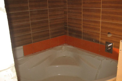 Example of a large minimalist brown tile and ceramic tile dark wood floor and brown floor bathroom design in Other with a wall-mount toilet, brown walls, an integrated sink, tile countertops and brown countertops