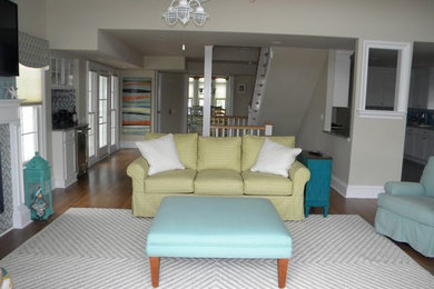Living room - huge coastal open concept medium tone wood floor living room idea in Philadelphia with beige walls, a standard fireplace, a wood fireplace surround and a wall-mounted tv