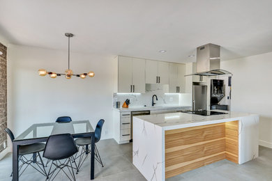 Mid-sized contemporary single-wall eat-in kitchen in Phoenix with flat-panel cabinets, white cabinets, stainless steel appliances, with island, grey floor, an undermount sink, quartz benchtops, white splashback, engineered quartz splashback, ceramic floors and white benchtop.