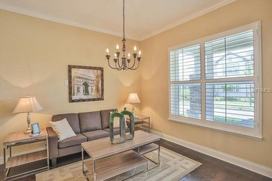 Example of a mid-sized transitional open concept dark wood floor and brown floor living room design in Orlando with beige walls