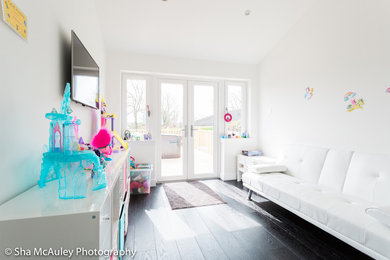 This is an example of a mid-sized contemporary kids' playroom for kids 4-10 years old in Glasgow with white walls and black floor.