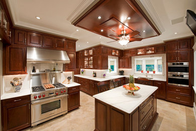 Example of a mid-sized classic u-shaped travertine floor kitchen pantry design in Philadelphia with an undermount sink, shaker cabinets, dark wood cabinets, marble countertops, white backsplash, subway tile backsplash, stainless steel appliances and an island