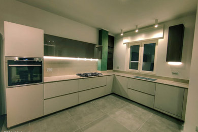 Immagine di un'ampia cucina minimal con lavello sottopiano, ante di vetro, ante grigie, paraspruzzi beige, paraspruzzi in granito, pavimento in gres porcellanato, pavimento grigio, top beige e soffitto ribassato