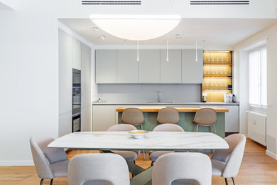 Foto di una grande cucina contemporanea con lavello sottopiano, ante lisce, ante grigie, top in marmo, paraspruzzi grigio, paraspruzzi in marmo, elettrodomestici neri, pavimento in legno verniciato, pavimento marrone, top grigio e soffitto ribassato