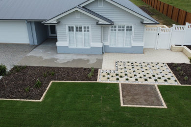 Large and australian native front yard full sun formal garden in Other with a retaining wall, concrete pavers and a vinyl fence for summer.