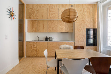 Inspiration pour une salle à manger ouverte sur la cuisine design de taille moyenne avec un mur blanc et parquet clair.