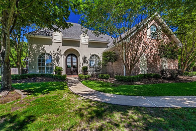 Large farmhouse brown two-story brick house exterior photo in New Orleans with a shingle roof