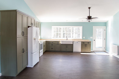 Example of a dark wood floor kitchen design in Portland Maine with brown cabinets and white appliances