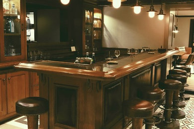 Traditional seated home bar in New York with shaker cabinets, dark wood cabinets and porcelain floors.
