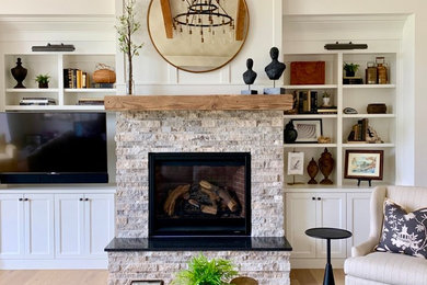 This is an example of a large country living room in Portland with white walls, a stone fireplace surround and brown floor.