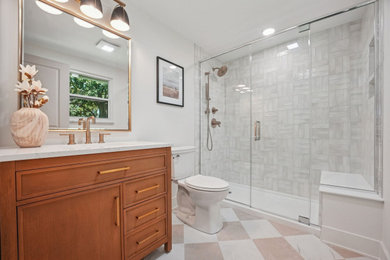 Inspiration for a gray tile and ceramic tile porcelain tile, beige floor and single-sink shower bench remodel in Columbus with light wood cabinets, white walls, an undermount sink, quartz countertops, a hinged shower door and white countertops