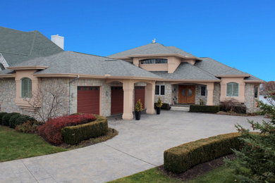 Large 1960s pink three-story stone house exterior idea in Other with a hip roof, a shingle roof and a gray roof