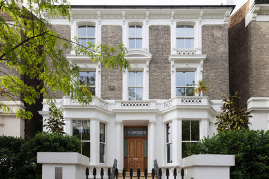 Inspiration for a large and beige contemporary brick semi-detached house in London with three floors, a flat roof and a mixed material roof.