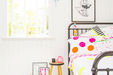 Design ideas for a mid-sized eclectic kids' bedroom for girls in Sydney with white walls and light hardwood floors.