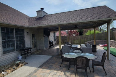 Transitional backyard brick patio photo in Other with a roof extension