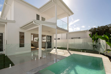 Pool - large tropical backyard tile and rectangular pool idea in Sunshine Coast