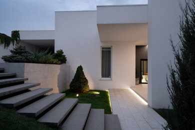 Стильный дизайн: одноэтажный, белый частный загородный дом среднего размера в современном стиле с комбинированной облицовкой и плоской крышей - последний тренд