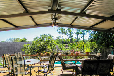 Large mountain style backyard deck photo in Austin with a roof extension