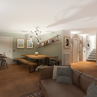 Imagen de sótano en el subsuelo ecléctico, grande, con paredes verdes, suelo de baldosas de porcelana, chimenea tradicional, marco de chimenea de yeso y suelo marrón