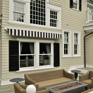 ニューヨークの巨大なトラディショナルスタイルのおしゃれな裏庭のデッキ (ファイヤーピット、オーニング・日よけ) の写真