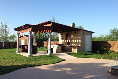 Example of a mid-sized classic backyard concrete paver patio kitchen design in Austin with a pergola