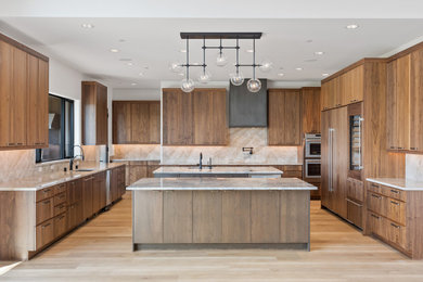 Large trendy u-shaped open concept kitchen photo in Seattle with a drop-in sink, flat-panel cabinets, brown cabinets, quartzite countertops, beige backsplash, quartz backsplash, two islands and beige countertops