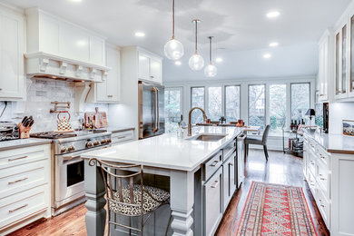 Photo of a mid-sized traditional galley eat-in kitchen in Kansas City with an undermount sink, shaker cabinets, white cabinets, quartz benchtops, grey splashback, marble splashback, stainless steel appliances, medium hardwood floors, with island, brown floor and grey benchtop.