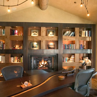 デンバーのモダンスタイルのおしゃれなホームオフィス・仕事部屋 (ベージュの壁、無垢フローリング、標準型暖炉、金属の暖炉まわり、自立型机) の写真