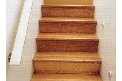 Foto de escalera en L minimalista de tamaño medio con escalones de madera, contrahuellas de madera y barandilla de madera