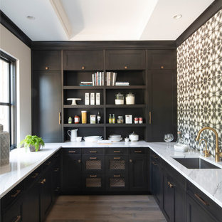 This is an example of a mid-sized country u-shaped kitchen pantry in Minneapolis with a single-bowl sink, brown cabinets, quartz benchtops, ceramic splashback, no island, shaker cabinets, multi-coloured splashback, light hardwood floors and white benchtop.